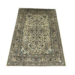 Persian Kashan ivory ground carpet, the field decorated profusely with interlacing branch and stylised plant motifs, scrolling border with overall floral design 