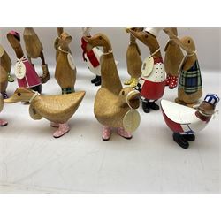 Quantity of the Duck Company UK DCUK carved bamboo root ducks, modelled wearing rain hats and rain boots etc, together with other similar carved wood ducks, tallest H26cm