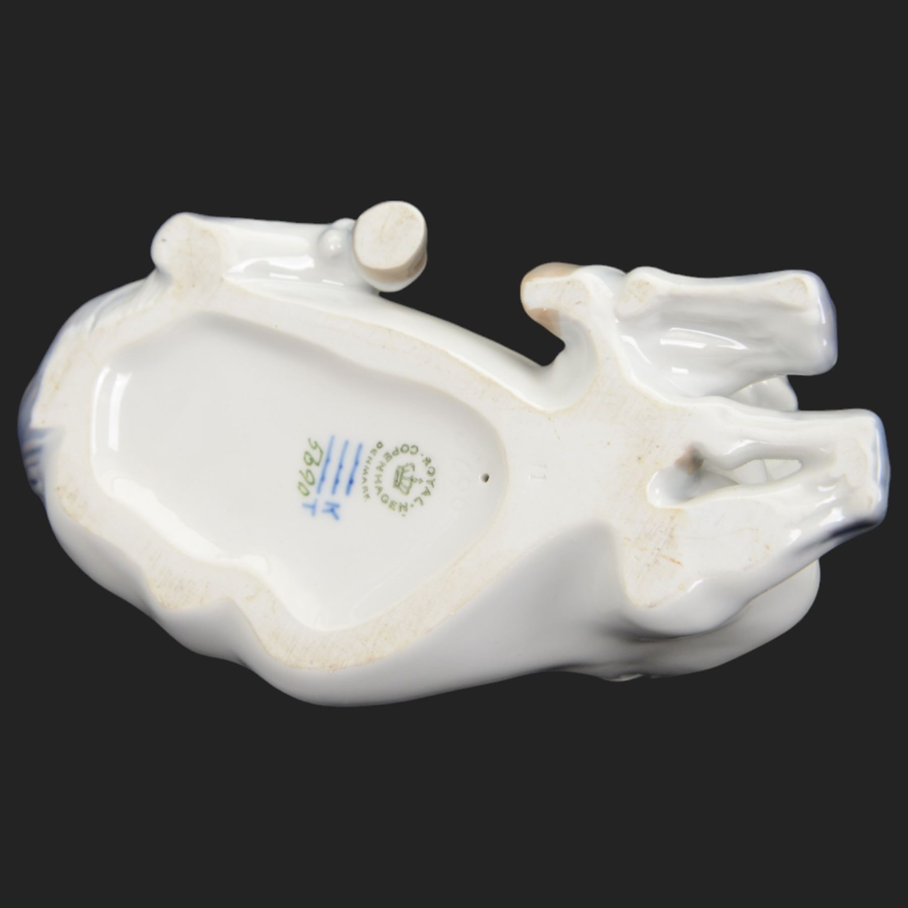 Two Royal Copenhagen figures modelled as Lippizaner horses, the first example in a recumbent pose no 5690, the second example prancing upon a stepped circular base, H19cm 