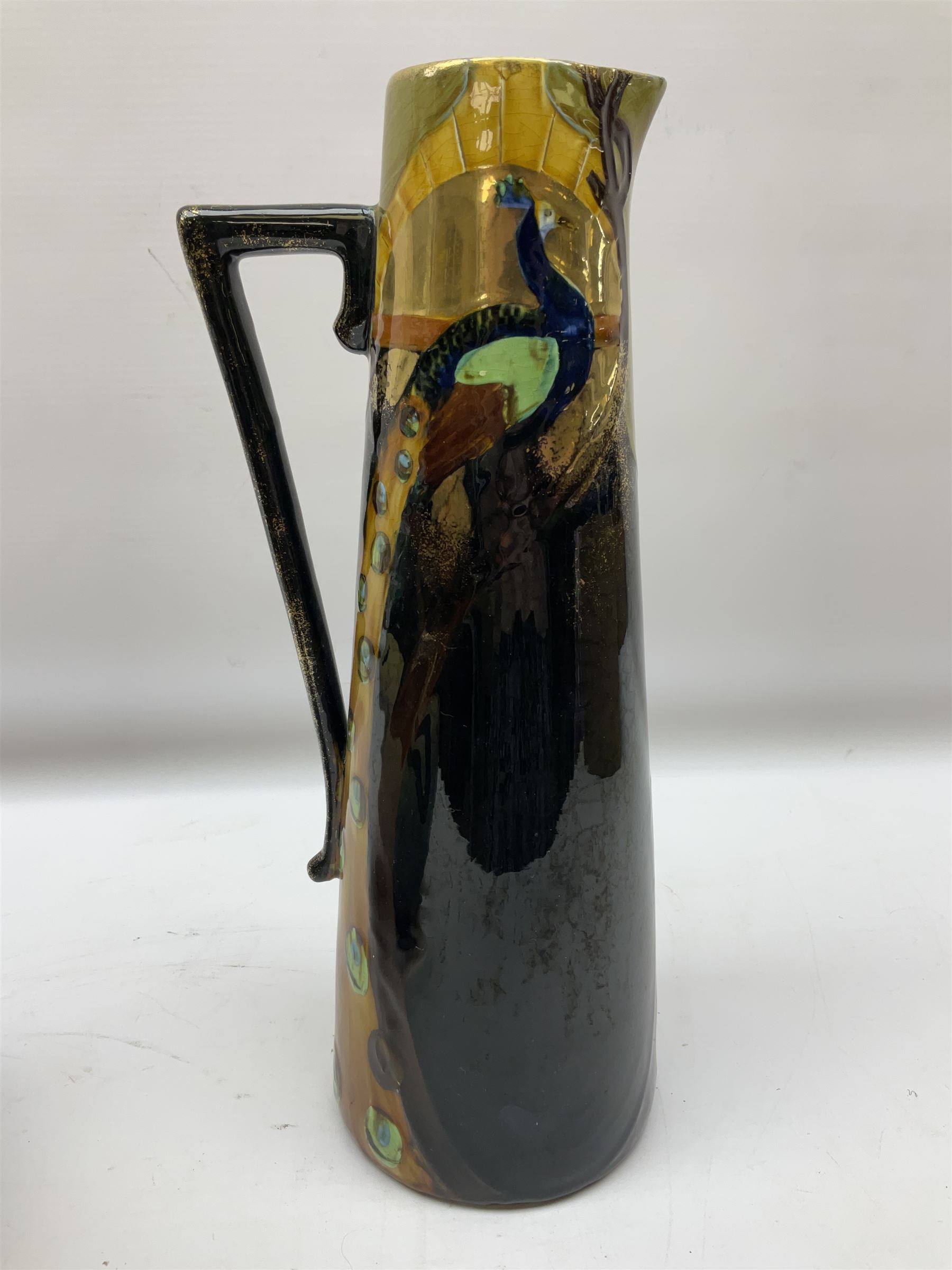 T. Forester Phoenix ware ewer of tapering form decorated with peacock and Bretby twin handled vase decorated with figures fishing in a boat sea scene