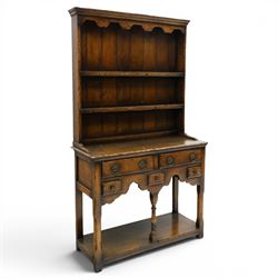 Georgian design oak dresser of small proportions, moulded cornice over open plate rack with two shelves and shaped apron, the base fitted with two drawers over three small drawers, brass drop handles, shaped apron, on square supports united by pot board