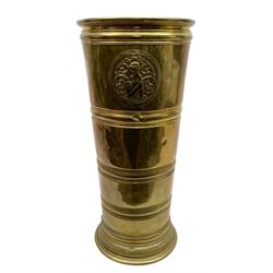 Brass stick stand, of tapering form, with circular embossed knight and shield crest, H55cm