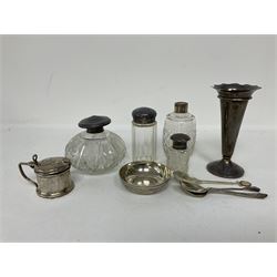 Group of silver, comprising trumpet vase with weighted base, hallmarked Mappin & Webb Ltd, Birmingham 1923, mustard pot and cover, hallmarked Docker & Burn Ltd, Birmingham 1922, with blue glass liner, a Persian silver dish set with coin, four cut glass bottles with silver collars and lids, two silver spoons and a silver plated spoon 
