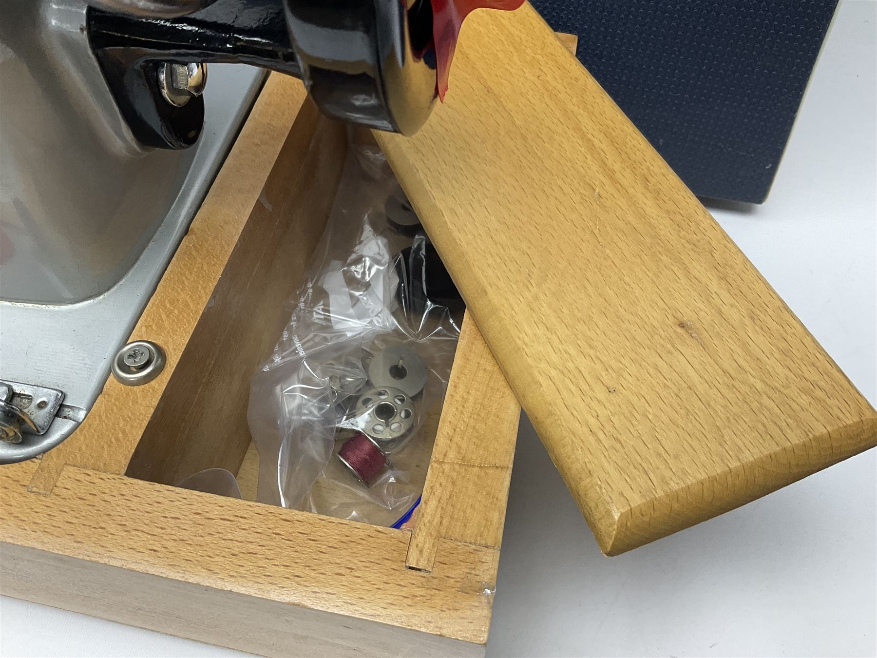 Seamstress sewing machine in case, together with a Singer sewing book