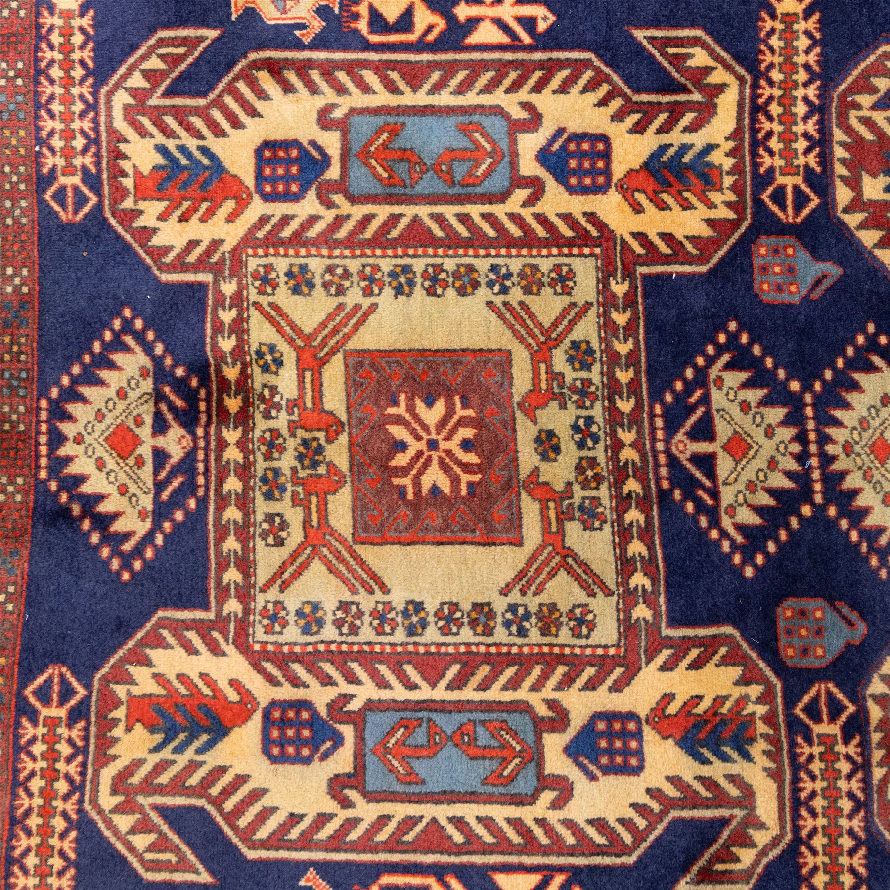 North West Persian Ardebil hand-knotted runner, indigo blue field composed of a repeating series of large stepped octagonal medallions enclosing a central hooked motif and stylized rosette, flanked by angular ivory and madder red latch hook devices, medallions linked by smaller geometric diamonds and serrated lozenges, guard borders with reciprocal motifs and main ivory border decorated with angular vines, with cotton fringe ends 