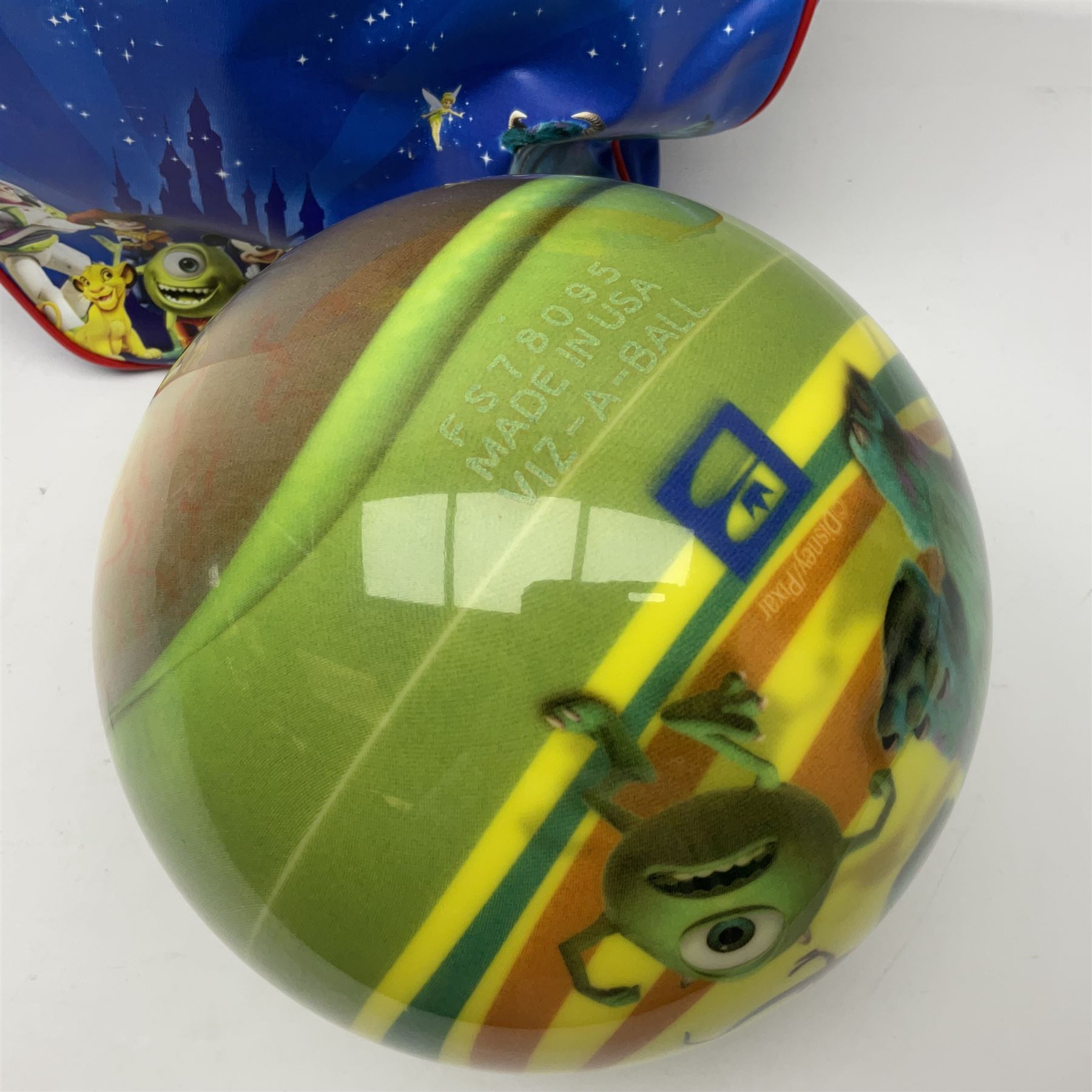 Two The Simpsons 'The Bowling Club' tenpin bowling balls, the first an undrilled example depicting Bart Simpson on a green ground, the second a drilled example depicting the Simpsons family on an orange ground, both in Simpsons The Bowling Club bags, together with a Disney Monsters, Inc. tenpin bowling ball, in matching bag and a Maxim tenpin bowling ball