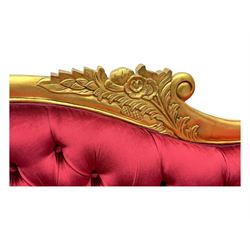 Victorian design giltwood chaise longue, the curved backrest and seat upholstered in deep red velvet with tufted detailing, the frame carved with floral motifs and scrolling acanthus leaves, raised on shaped cabriole supports
