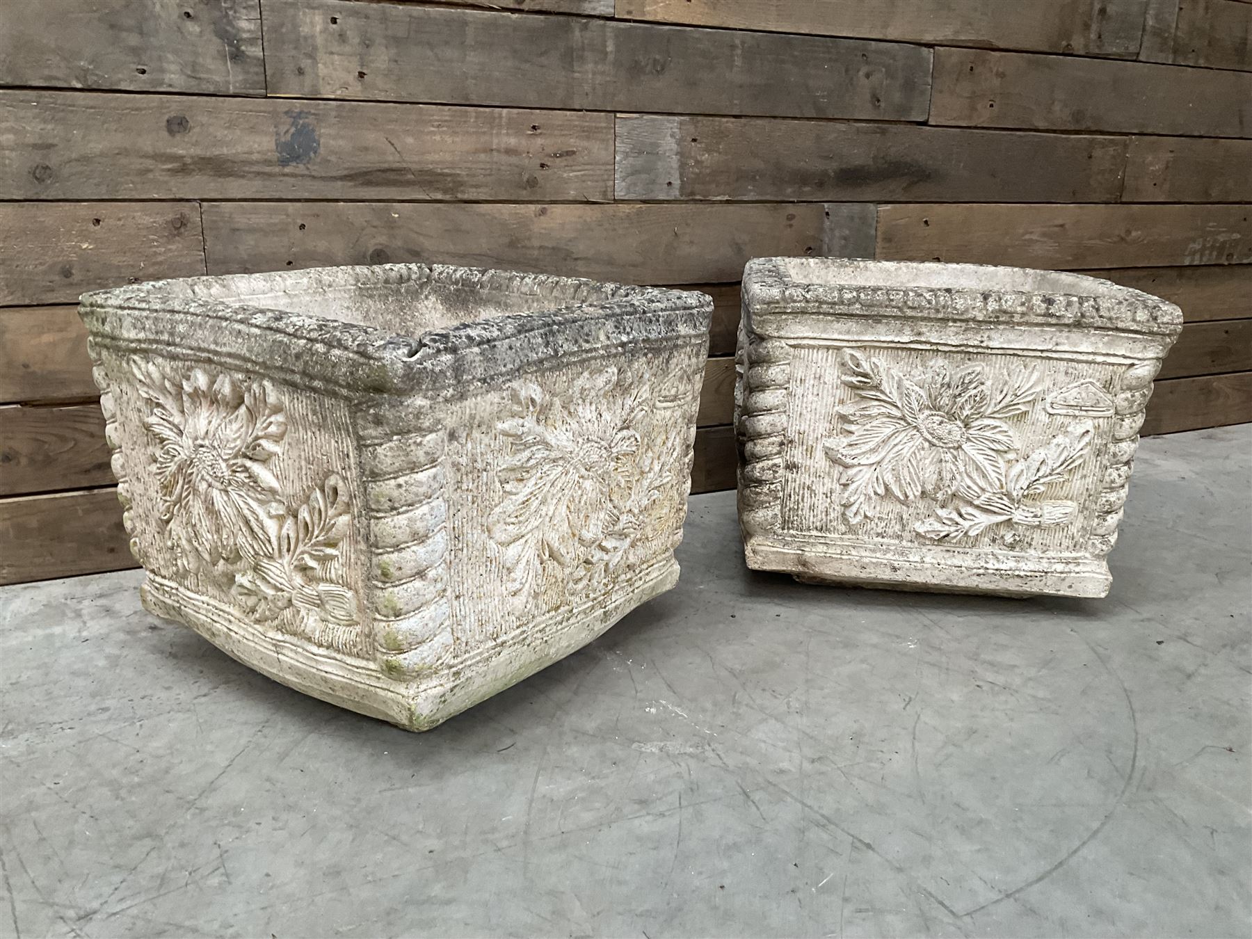 Pair of weathered cast stone square garden planters, leaf decoration
