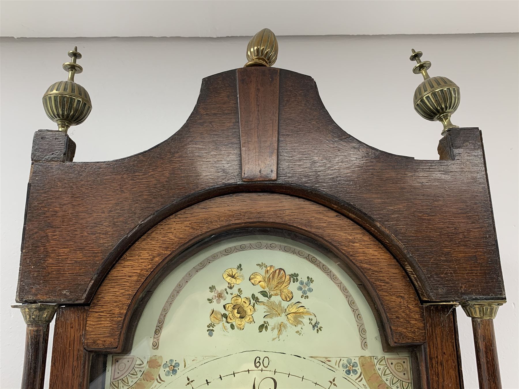 Early 19th century oak longcase clock, shaped pediment over a stepped arch glazed door enclosed by plain pilasters, the case with canted corners and trunk door with sloped arch top and centre curved return, enamel Arabic dial painted with flowers and patterned spandrels, signed 'Jno. Hilbert, Haxby', eight-day movement with subsidiary seconds dial and false calendar dial 