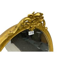 Victorian design gilt framed oval wall mirror, cartouche pediment with extending foliate decoration and C-scrolls, the lower edge moulded with fruit garlands