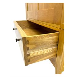 Contemporary light oak double wardrobe, projecting cornice over two panelled doors enclosing hanging rail and shelf, above full-width drawer, on shaped stile supports