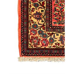 North West Persian Sarouk peach ground rug, the field decorated with floral bunches, pale ground border with repeating flower head motifs within guard stripes 