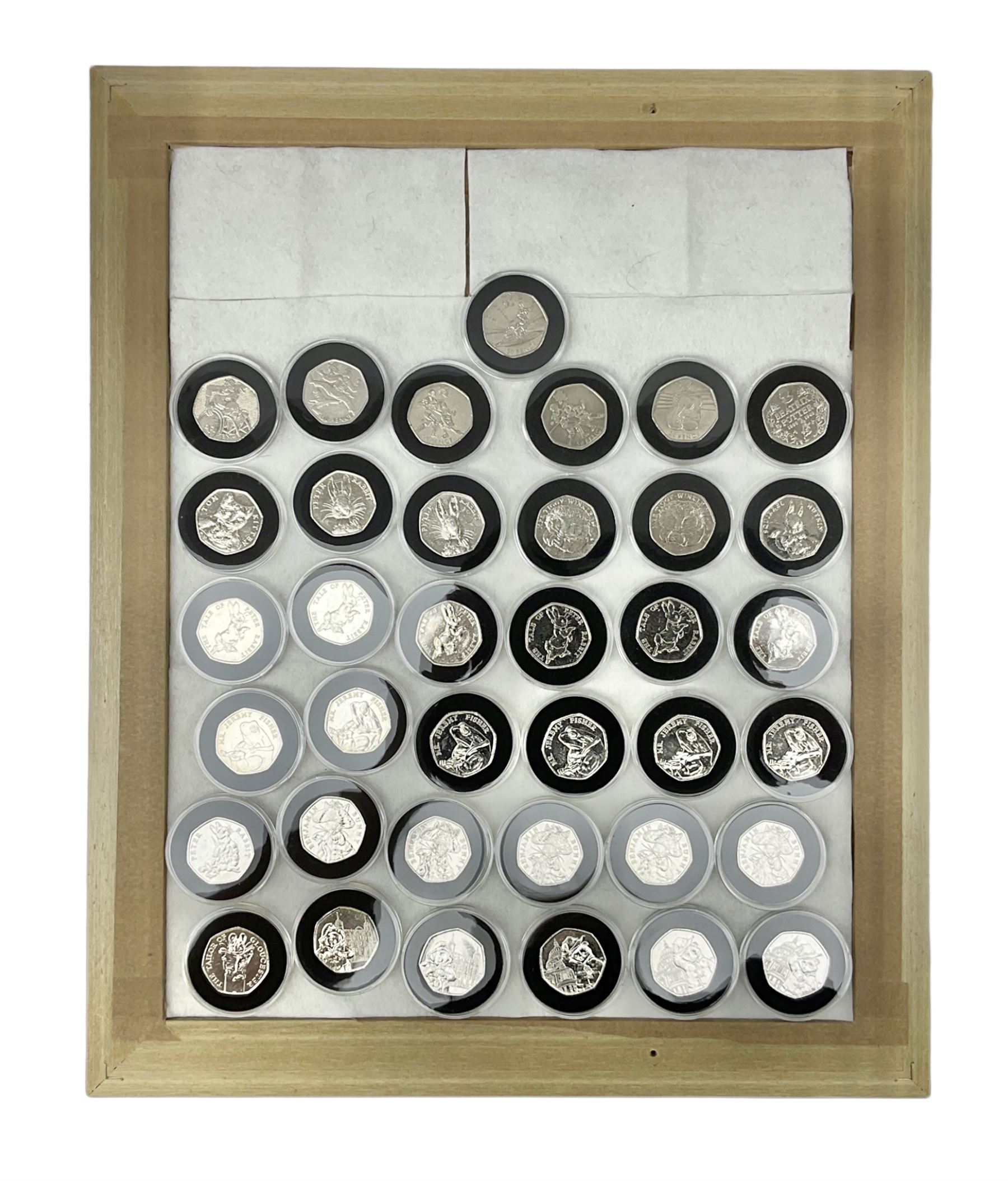Thirty-seven commemorative fifty pence coins, including 2011 wrestling, other Olympics, Beatrix Potter etc, housed in capsules