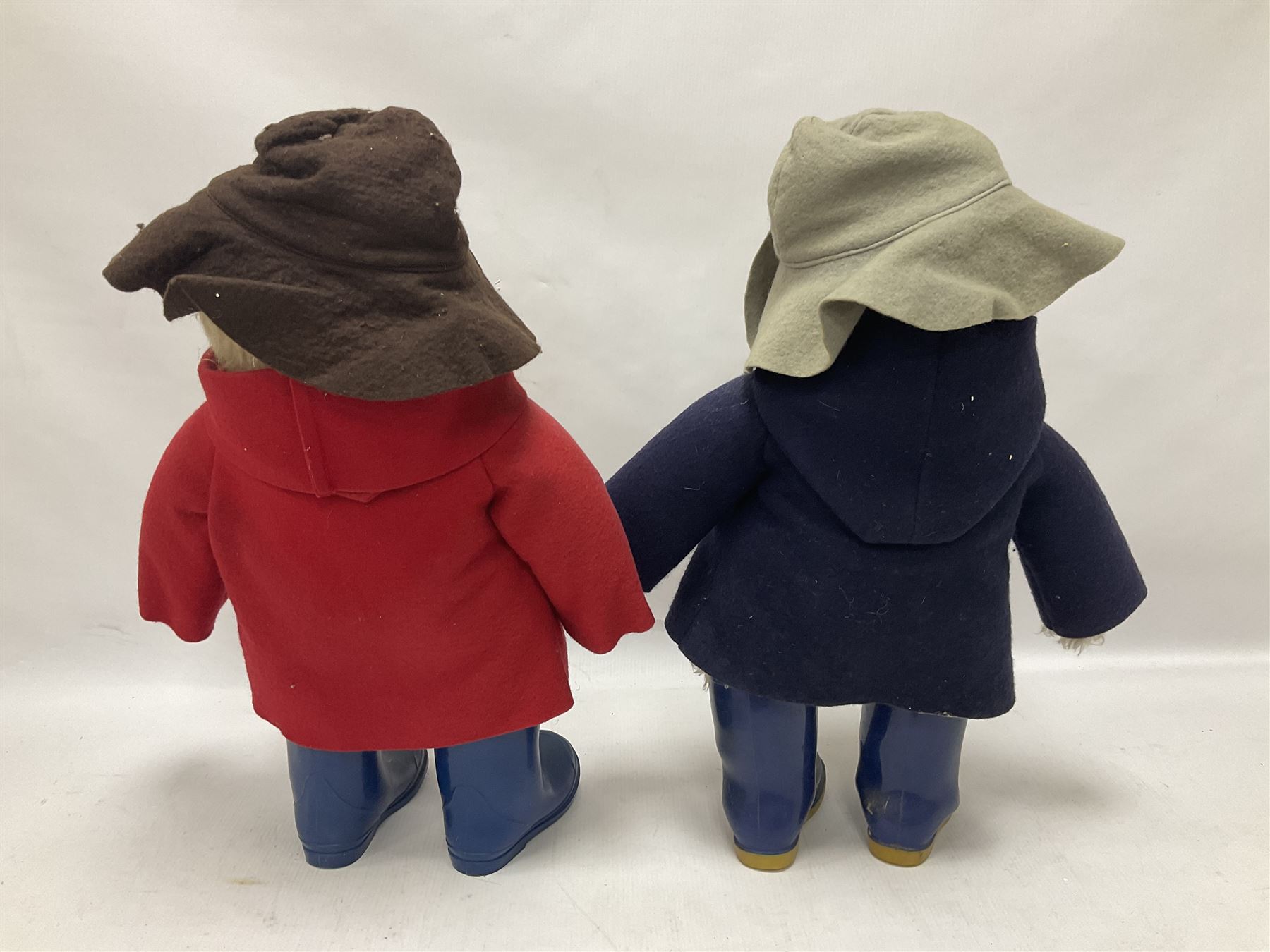 Pair of Paddington Bear teddies with amber eyes, the first example having a brown felt hat, red coat and blue PB boots with original label; the second having a grey felt hat, blue coat and blue Dunlop boots, tallest H51cm 