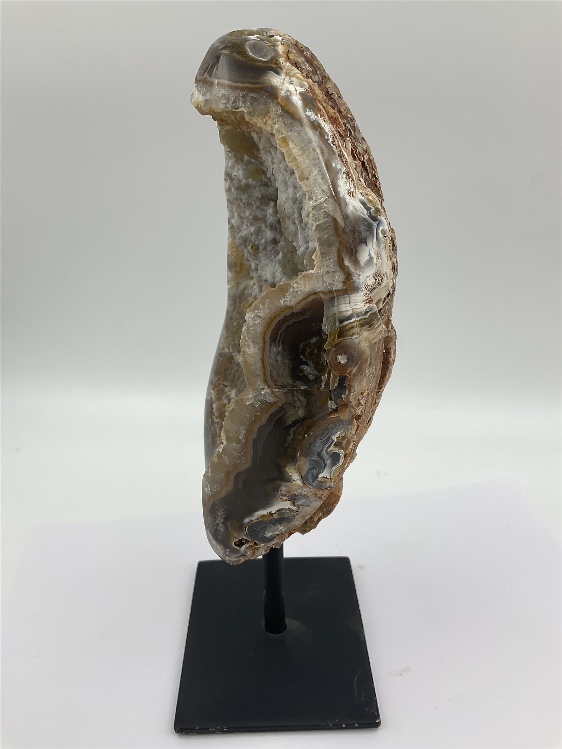 Agate crystal geode cluster, in brown and purple tones, upon a metal stand, H26cm