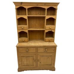 Solid pine dresser, raised plate rack fitted with small drawers over two drawers and double cupboard, plinth base