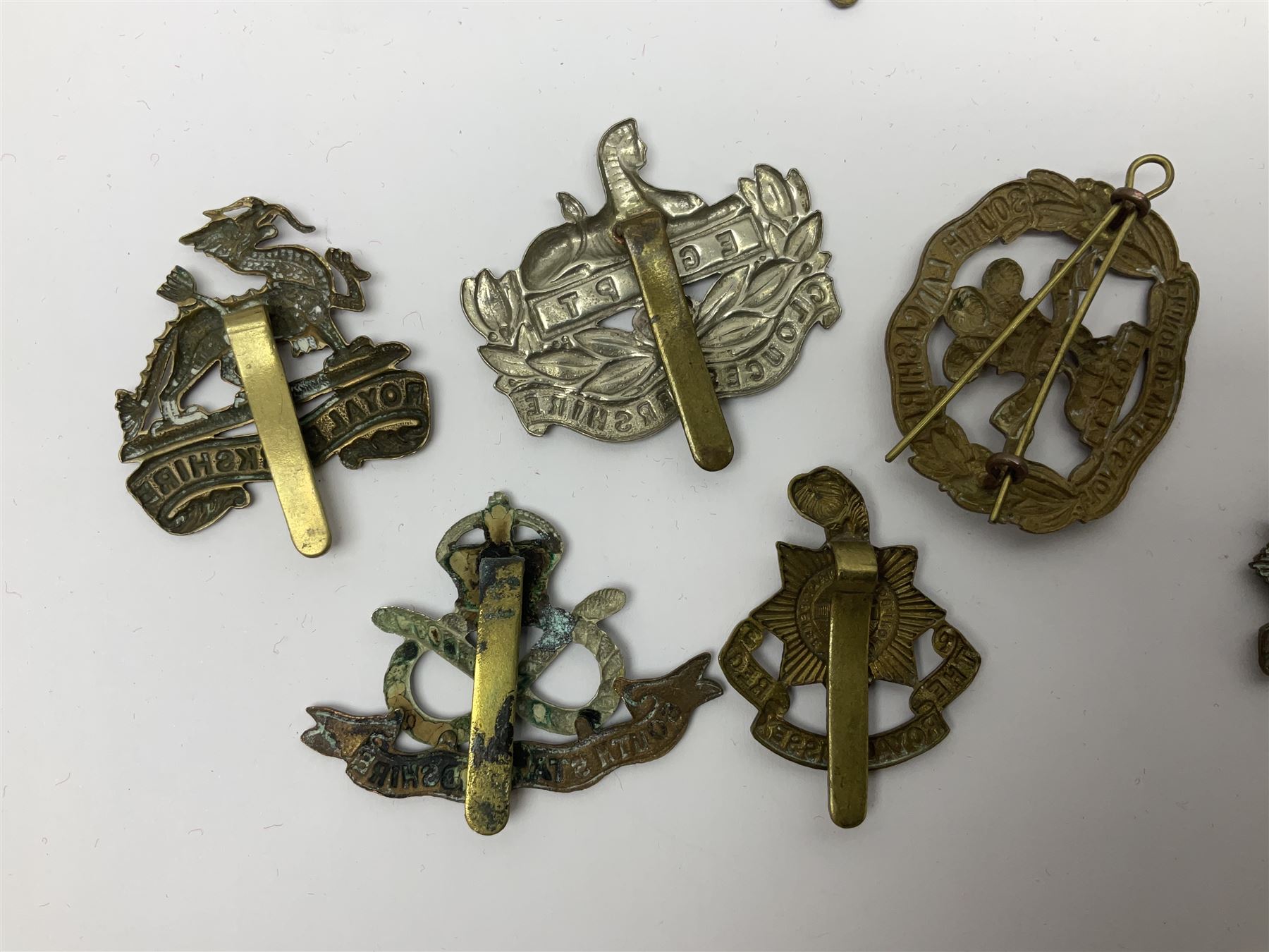Seventeen regimental cap badges including Dorsetshire, Worcestershire, Staffordshire, Lancashire, Manchester, Middlesex, Berkshire, Bedfordshire etc (17)