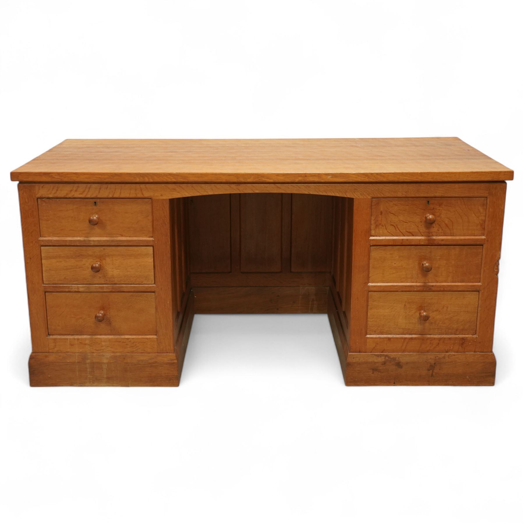 Mouseman - oak pedestal kneehole desk, adzed rectangular top over twin pedestals each fitted with three drawers, arched kneehole with panelled interior, on plinth base, signature carved mouse to side, by the workshop of Robert Thompson, Kilburn