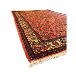 North West Persian Sarouk peach ground rug, the field decorated with floral bunches, pale ground border with repeating flower head motifs within guard stripes 
