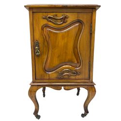 Edwardian Art Nouveau walnut bedside cabinet, raised broken swan neck back with carved flower heads, single fielded panelled door enclosing single shelf, raised on cabriole supports with ceramic castors