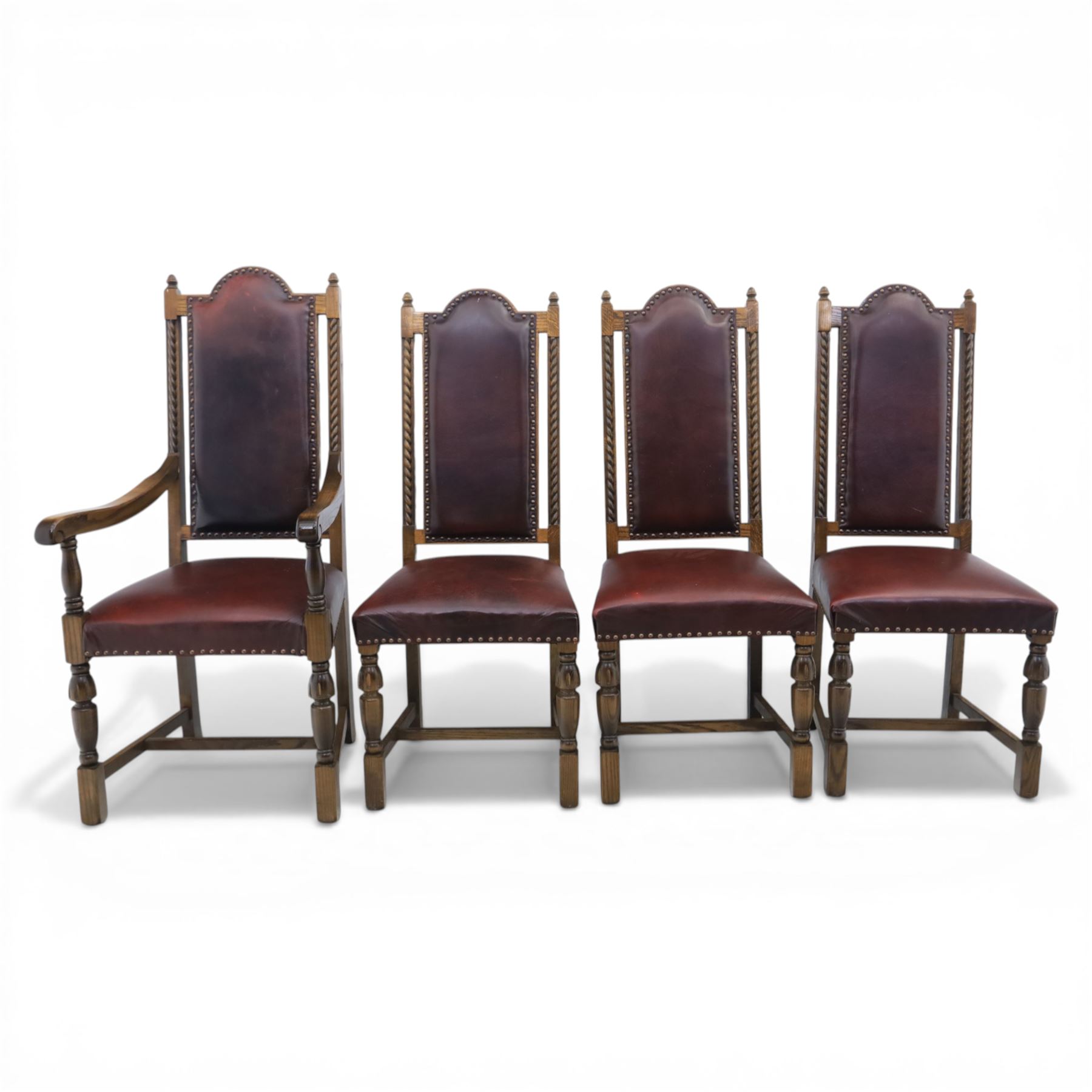 Carolean revival oak dining table and eight chairs (7+1), refectory table with rectangular boarded top and cleated ends, raised on shaped trestle end supports with central stretcher, accompanied by eight high-back chairs including a carver, leather upholstered panels and seats with studwork, on turned legs with stretchers.