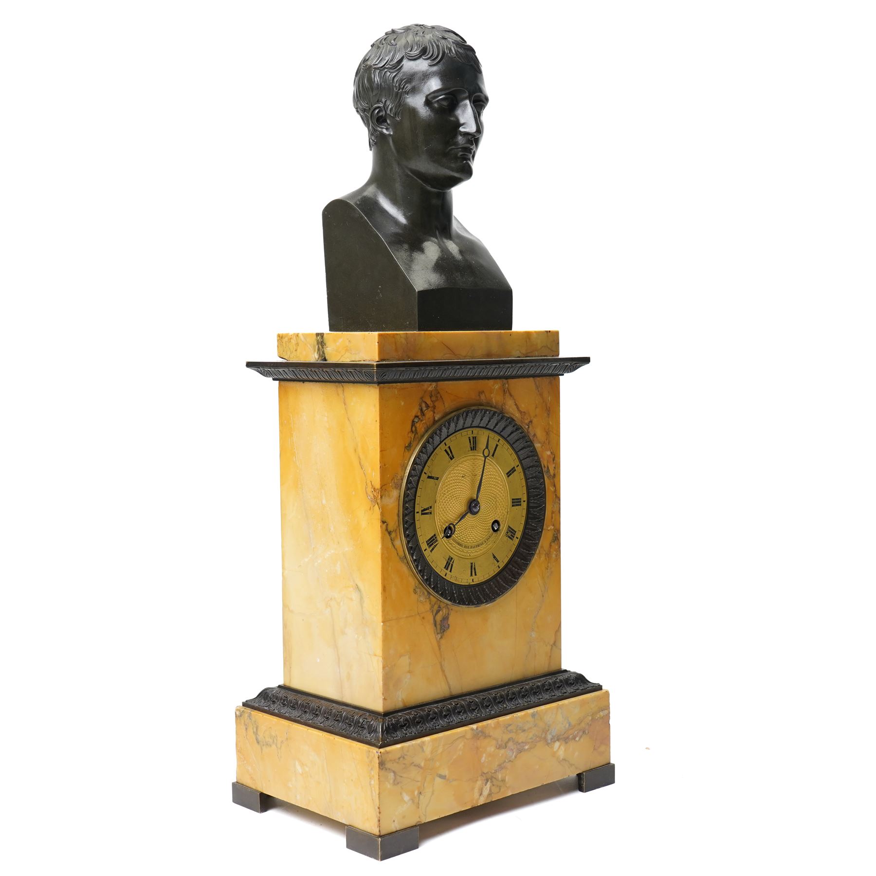 French-First quarter 19th century 8-day sienna marble and bronze-mounted mantel clock of rectangular architectural form, with patinated foliate guilloche pattern cast bronze mounts  in richly figured sienna marble, surmounted a by a classical patinated bronze bust of Napoleon Bonaparte, above a gilt engine turned dial with Roman numerals and blued steel hands, with a twin train Parisian countwheel striking movement, striking the hours and half-hours on a bell, silk suspension with thumb-screw adjustment. With pendulum.