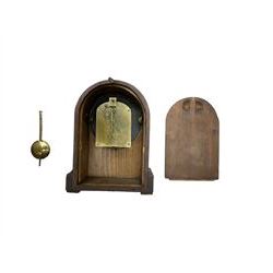 French - late 19th century 8-day walnut table clock, with a round top and shallow plinth raised on block feet, enamel dial with Roman numerals and minute track and decorative pierced steel hands within a gilt slip and cast brass bezel, single train movement with a spring driven going barrel. With pendulum. 