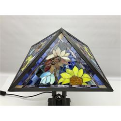 Tiffany style table lamp, the shade with four mosaic glass panels depicting sunflowers on a blue marble effect ground, raised upon a bronzed metal geometric base, H53cm