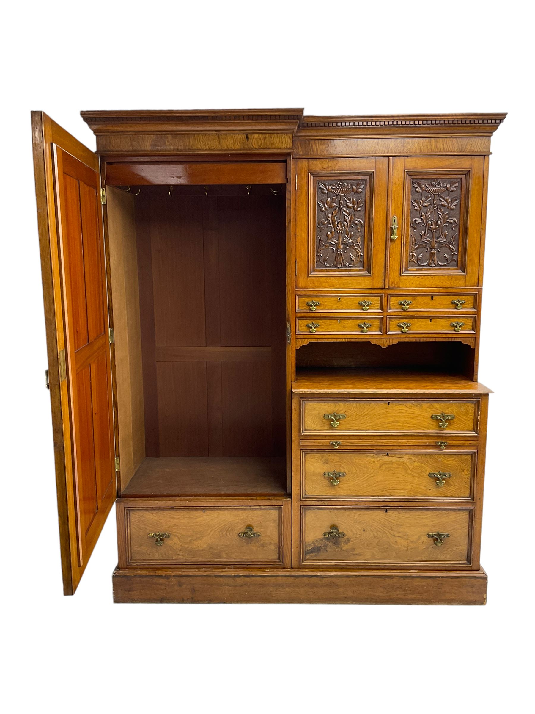 Victorian figured oak and pollard oak combination wardrobe, projecting dentil cornice, the left hand side enclosed by large bevelled mirror glazed door over drawer, the interior with sliding hanging rail, the right hand side with cupboard enclosed by two panelled doors relief carved with urn and trailed trailing foliage, four small drawers over shelf, three drawers and brushing slide, the slide with tooled and gilt blue leather inset, plinth base