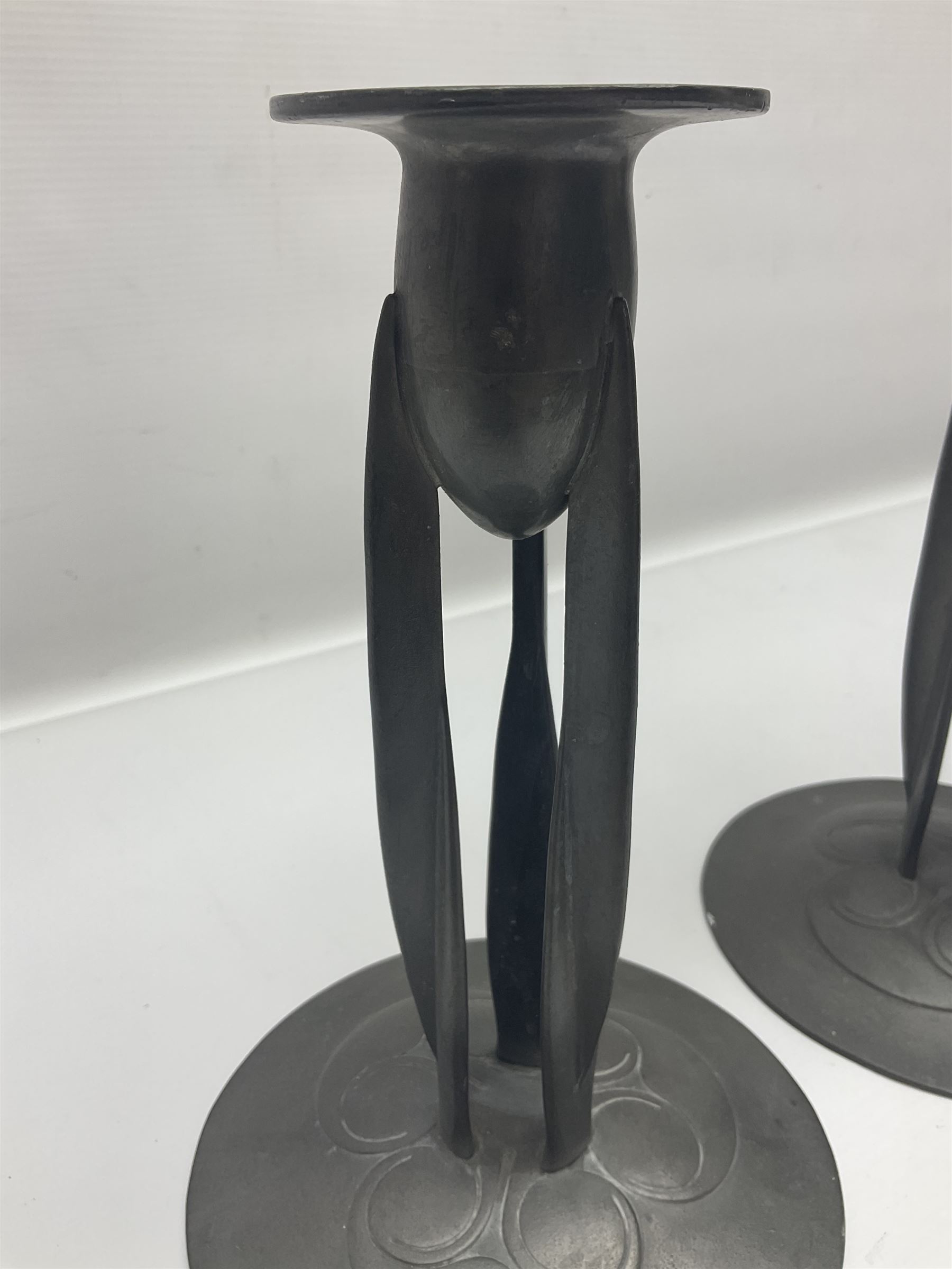 Pair of Solkets English pewter candlesticks, the bud shaped sockets raised upon three angular fin supports and a slightly domed circular base with cast stylised foliate decoration, H23cm