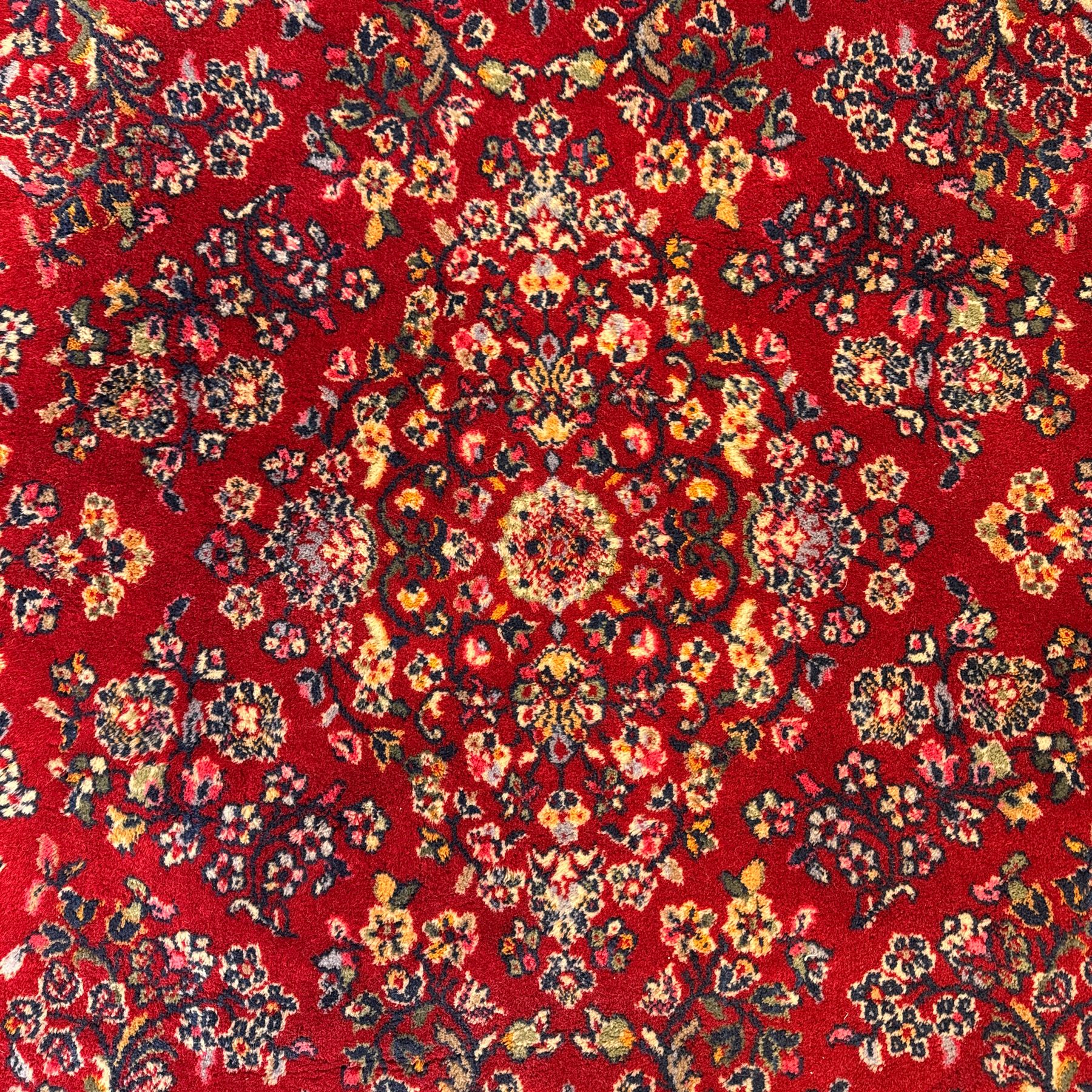 Persian Isfahan-style hand-knotted rug, crimson ground, with an intricated all-over floral spray design with palmettes and leaves, wide midnight blue main border with rosette and palmette motif, flanked by narrow guard borders  