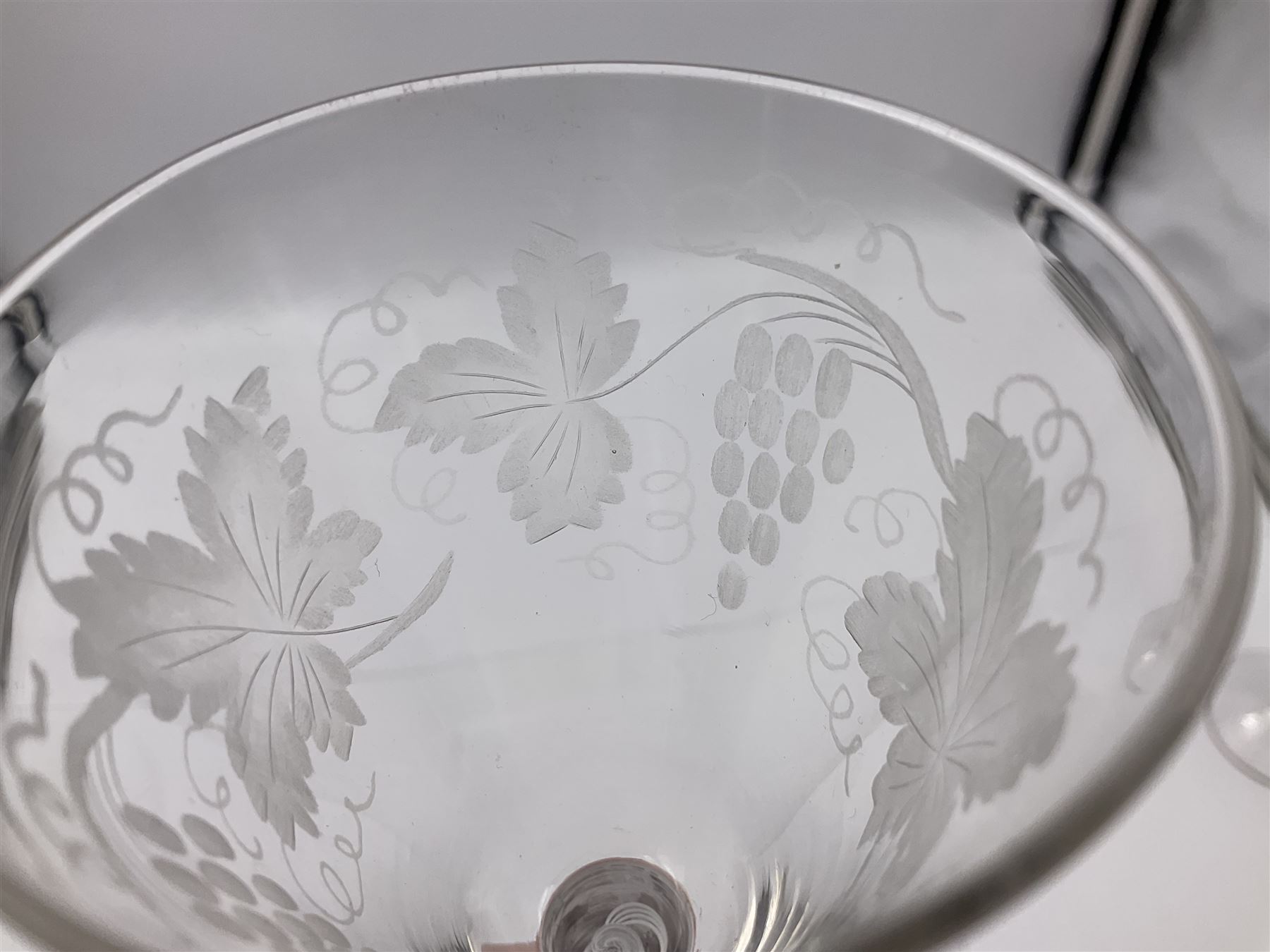 Set of three 18th century style wine glasses, each with funnel bowl etched with fruit vine, upon a double series air twist stem and circular foot, H17cm