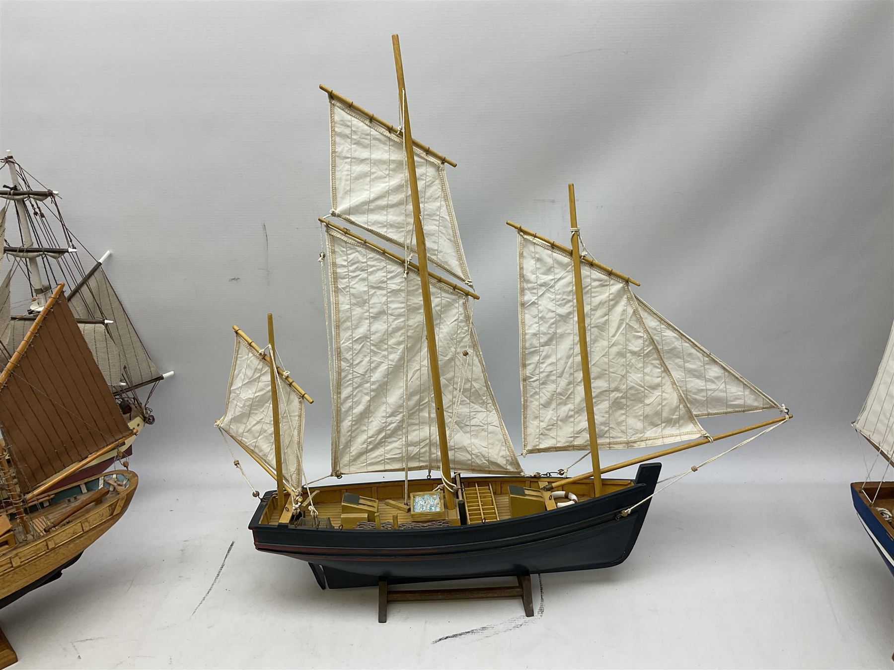 Eight model ships or boats including fishing boat with fish, nets and buoyancy aid, two mast sailing ship complete with cannons, two mast yacht with detailed rigging and life boat etc, the largest L72cm, H60cm