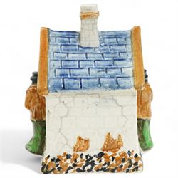 Yorkshire Prattware cottage, circa. 1820, in shades of blue, ochre and white, moulded in relief with two flanking gentlemen figures, H12cm 