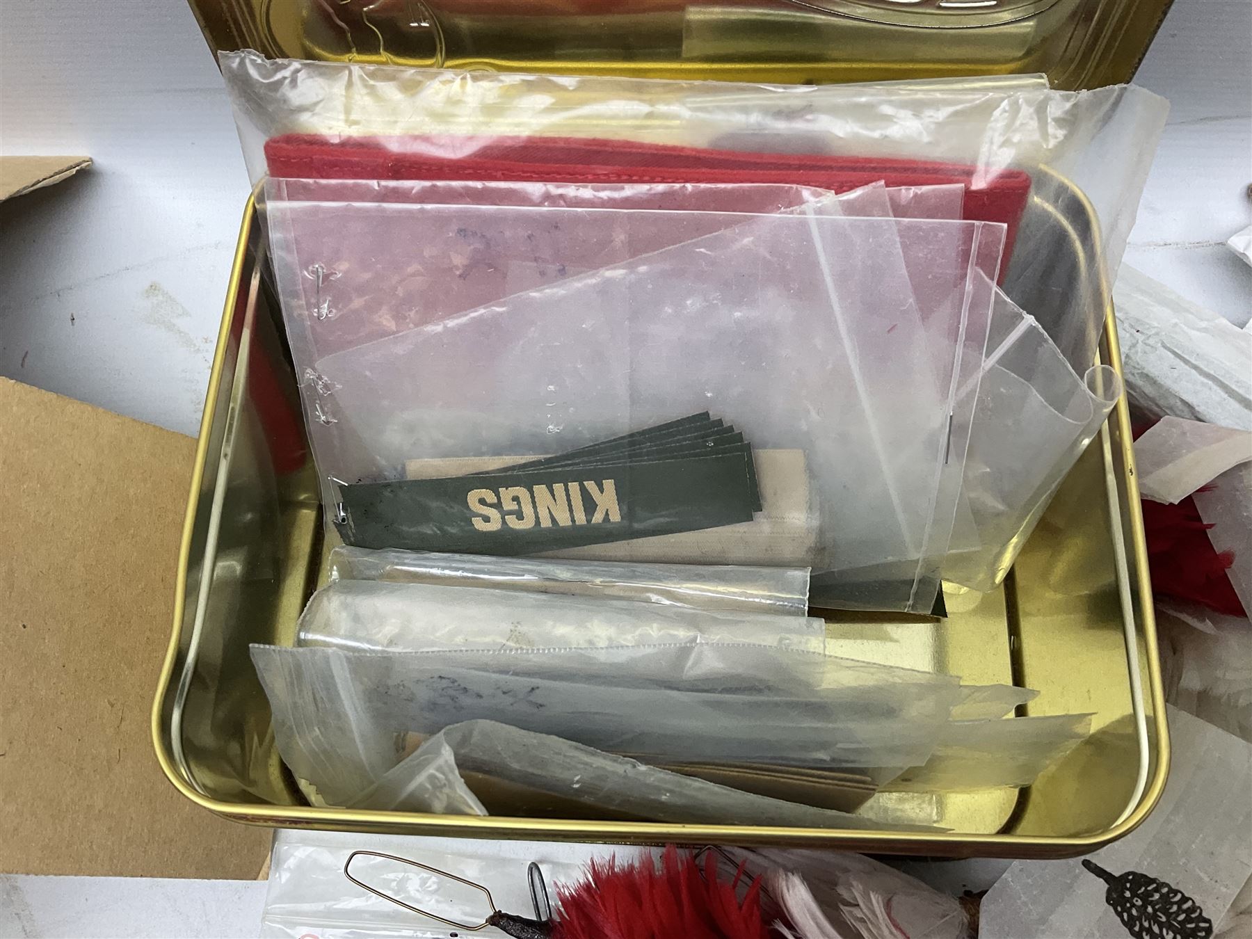 Quantity of military horse hair plumes and feather hackles, cloth stripes and regimental titles etc