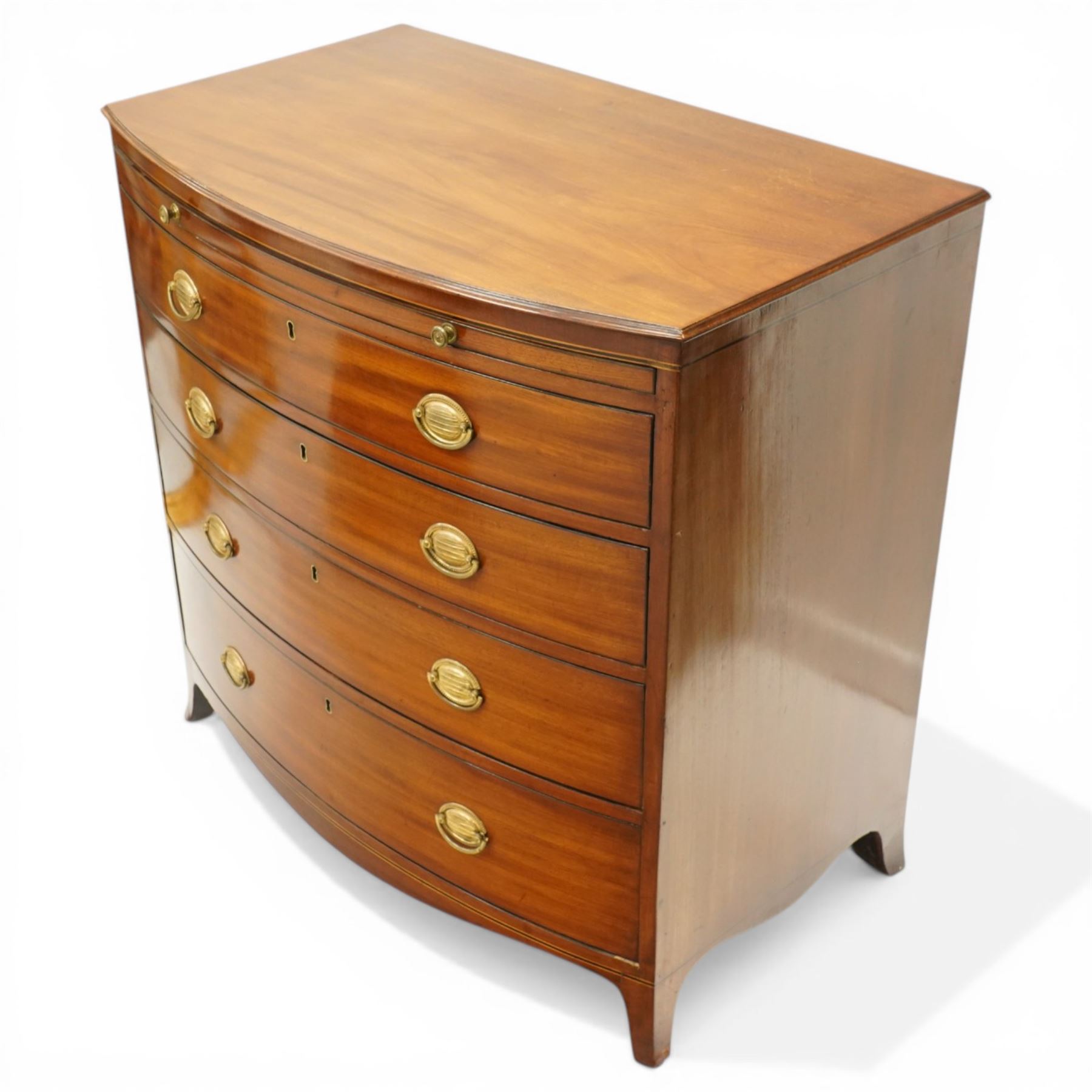 Regency period mahogany bow-front bachelor's chest, shaped top with moulded edge, fitted with brushing slide over four long graduating drawers, each with original pressed brass handle plates, raised on splayed feet 