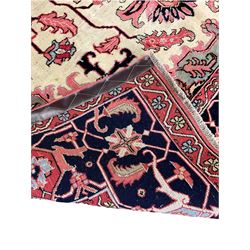 North West Persian Heriz carpet, ivory ground with large central medallion and floral spandrels, triple band border with scrolling design decorated with flower head and plant motifs 