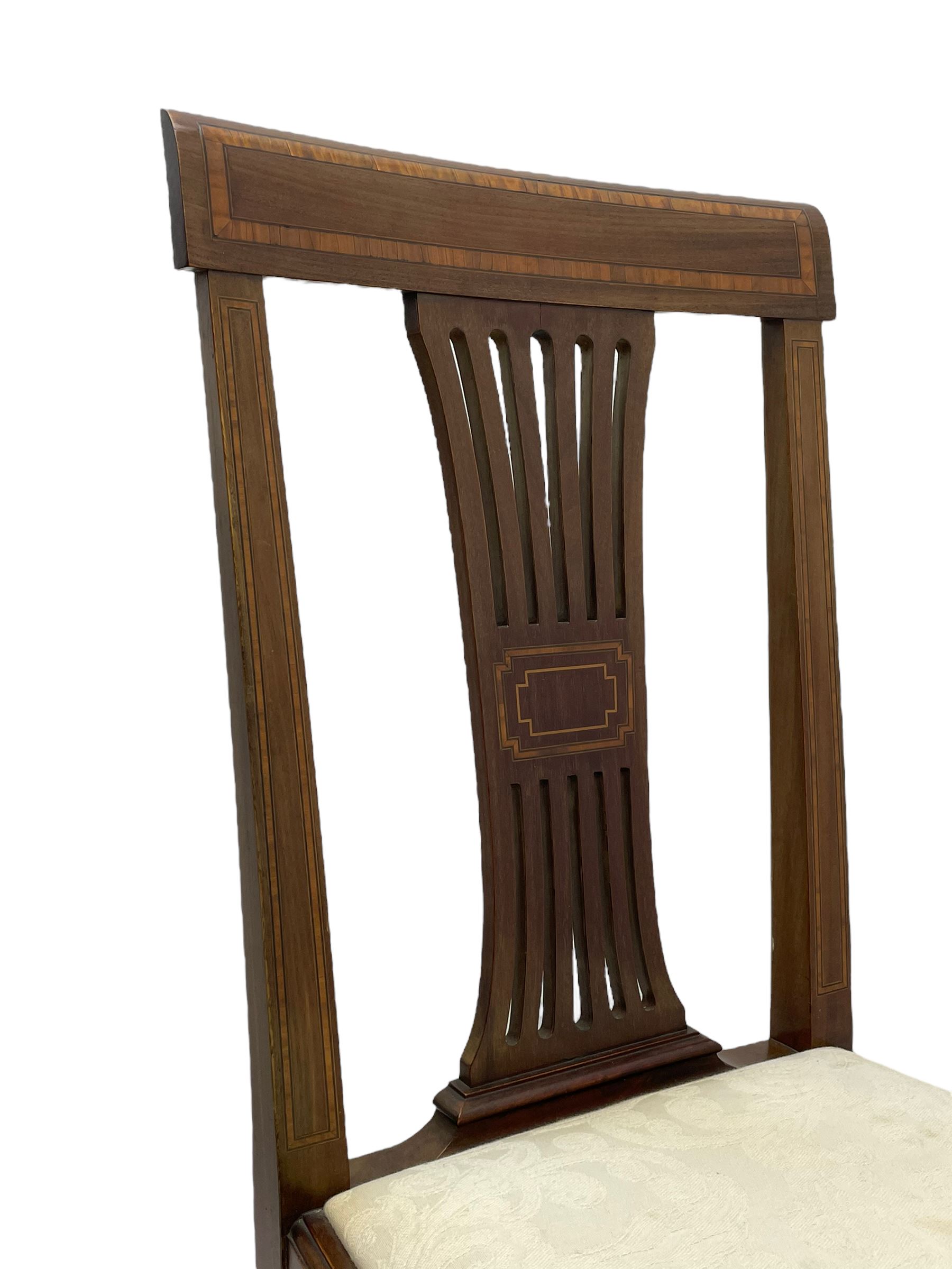 Set twelve (4+8) Edwardian inlaid mahogany dining chairs, cresting rail with satinwood banding, pierced splat backs with central inlay, drop-in seats upholstered in foliate patterned ivory fabric, raised on square tapering supports terminating in spade feet