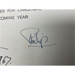 HM Queen Elizabeth II and HRH the Duke of Edinburgh, 1967 Christmas card with two gilt cyphers to front, tipped-in colour print of the Royal Family standing under an archway in Buckingham Palace, signed Elizabeth R and Philip with manuscript date 1967 below