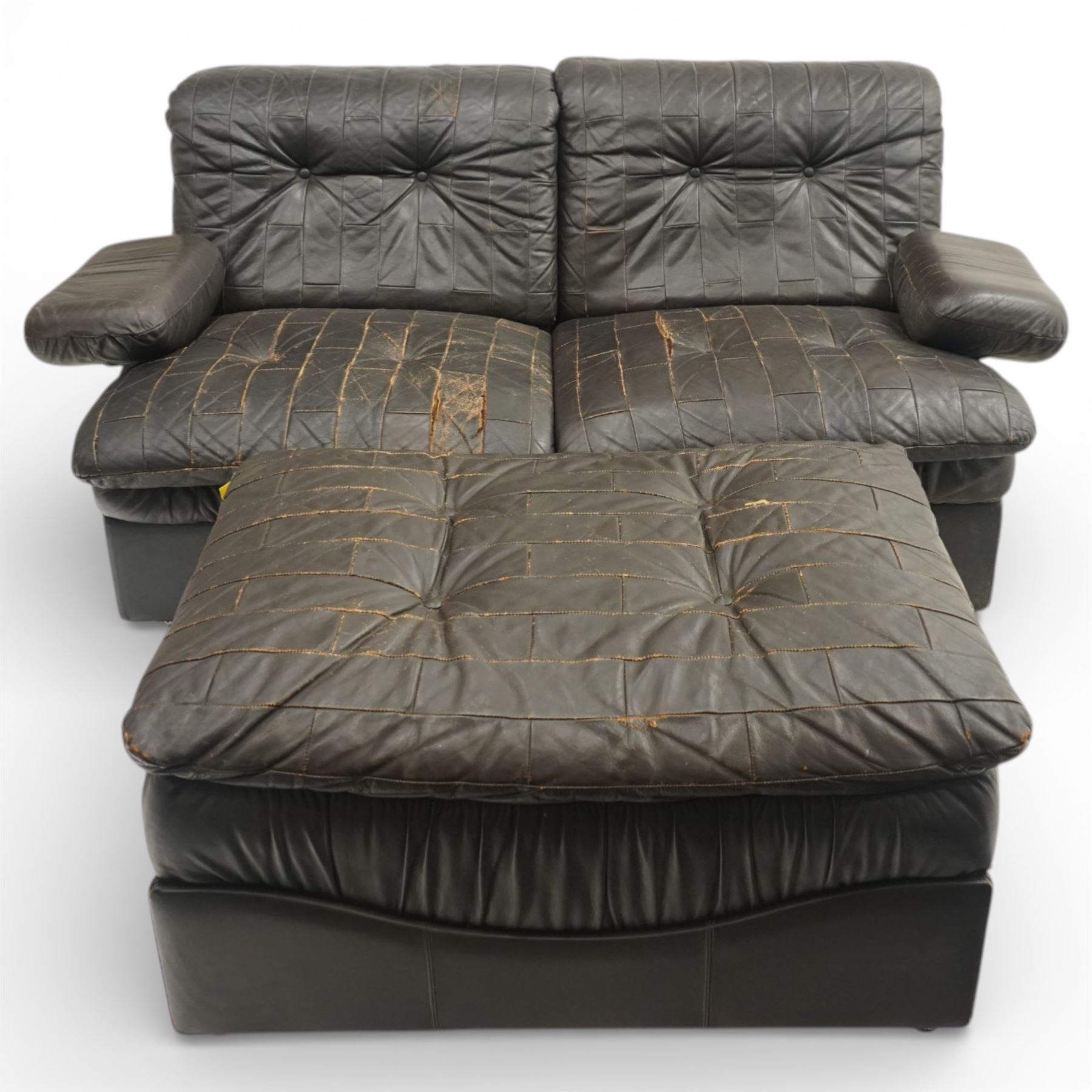 Mid 20th century leather upholstered two-piece sectional sofa with footstool, buttoned back cushions with stitched panel decoration, padded armrests and deep seat cushions, raised on concealed supports