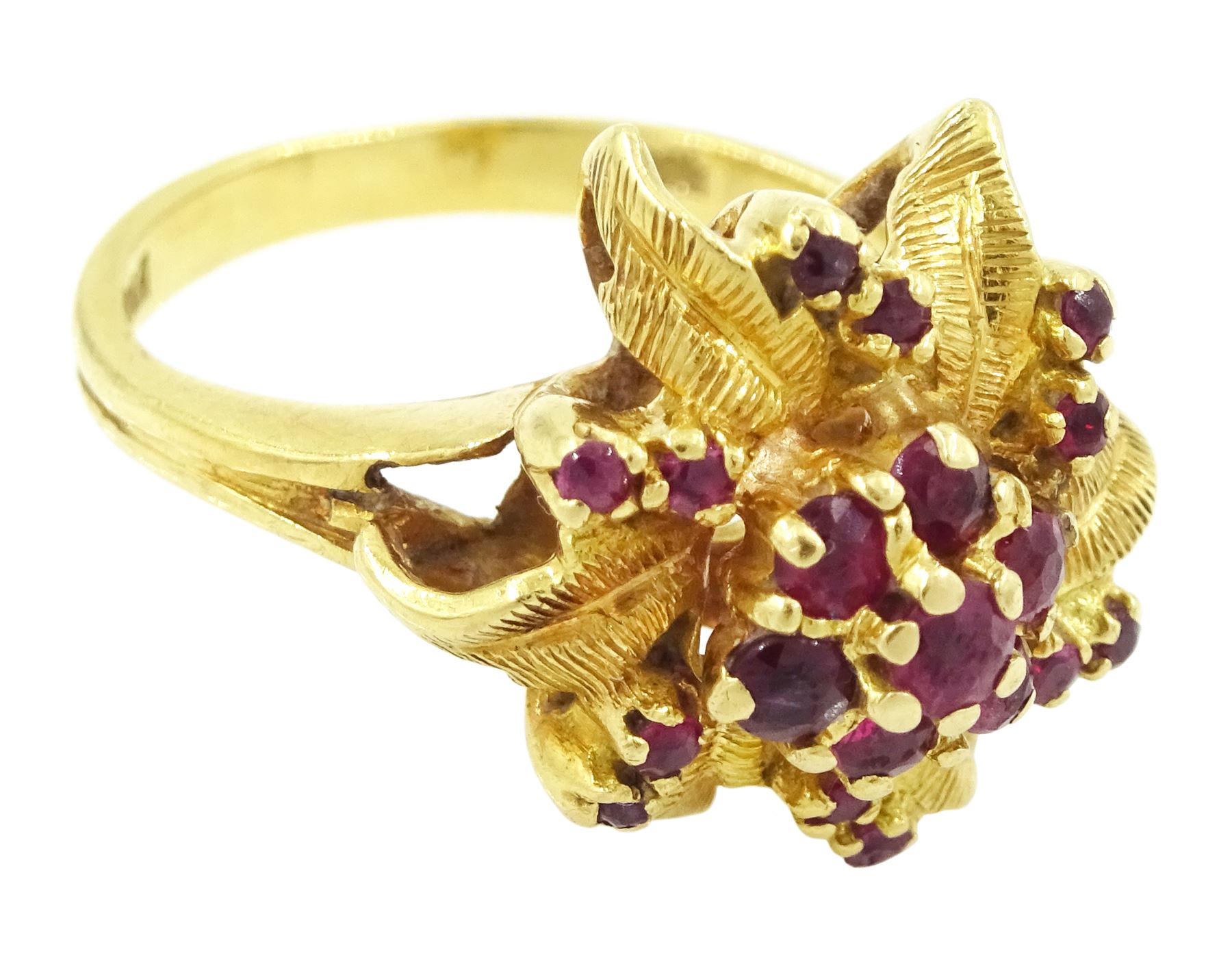 18ct gold ruby flower head cluster ring, seven round cut rubies surrounded by textured leaves, each spaced by two rubies, stamped 750
