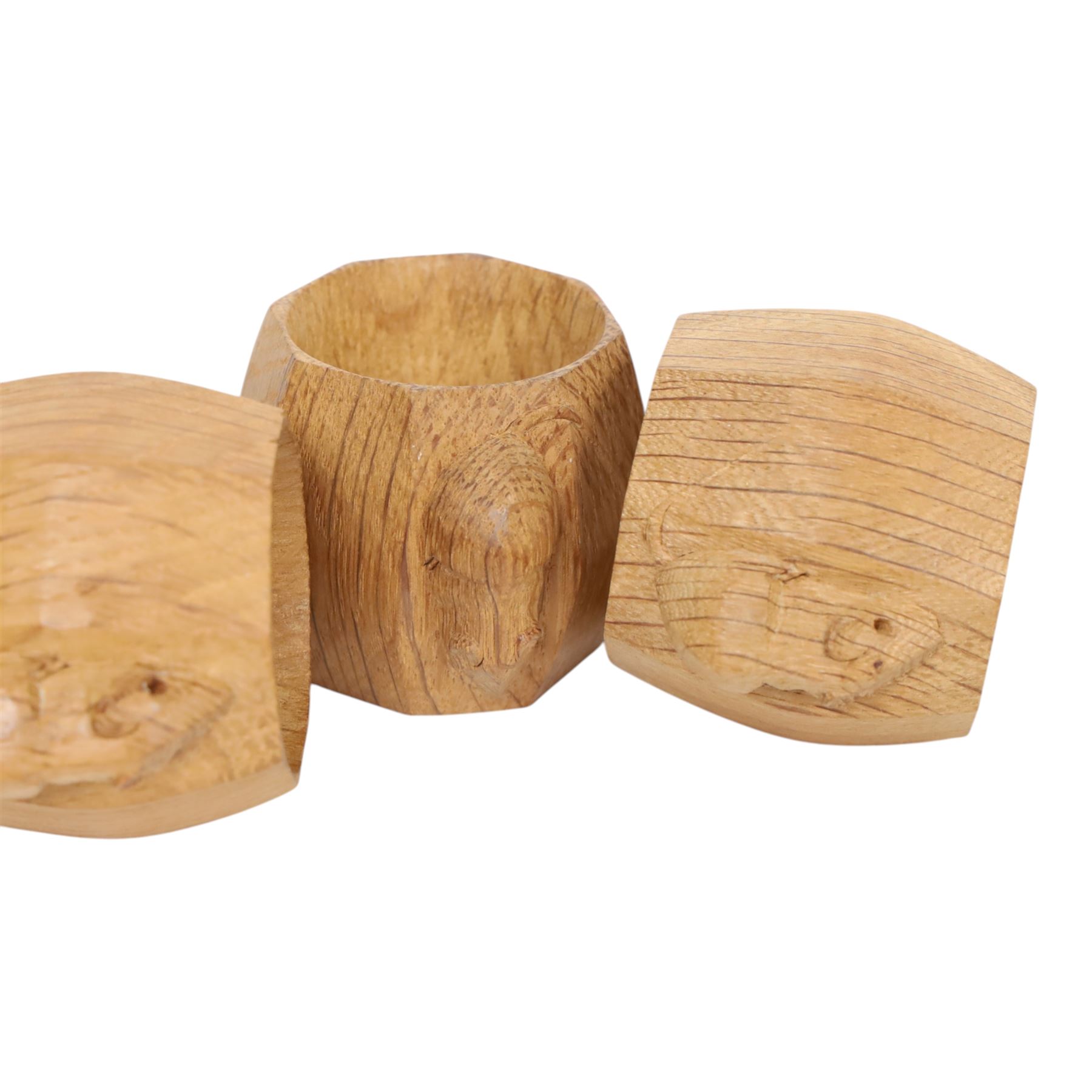 Mouseman - four light oak napkin rings, of bulbous octagonal form with signature mouse carving by Robert Thompson of Kilburn
