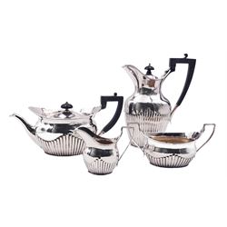Early 20th century four piece silver tea service, comprising teapot and hot water pot with ebonised handles and finials, twin handled open sucrier, and milk jug, each of oval part fluted form, hallmarked Edward Barnard & Sons Ltd, London 1919 and 1911, approximate gross weight 41.19 ozt (1281.3 grams)