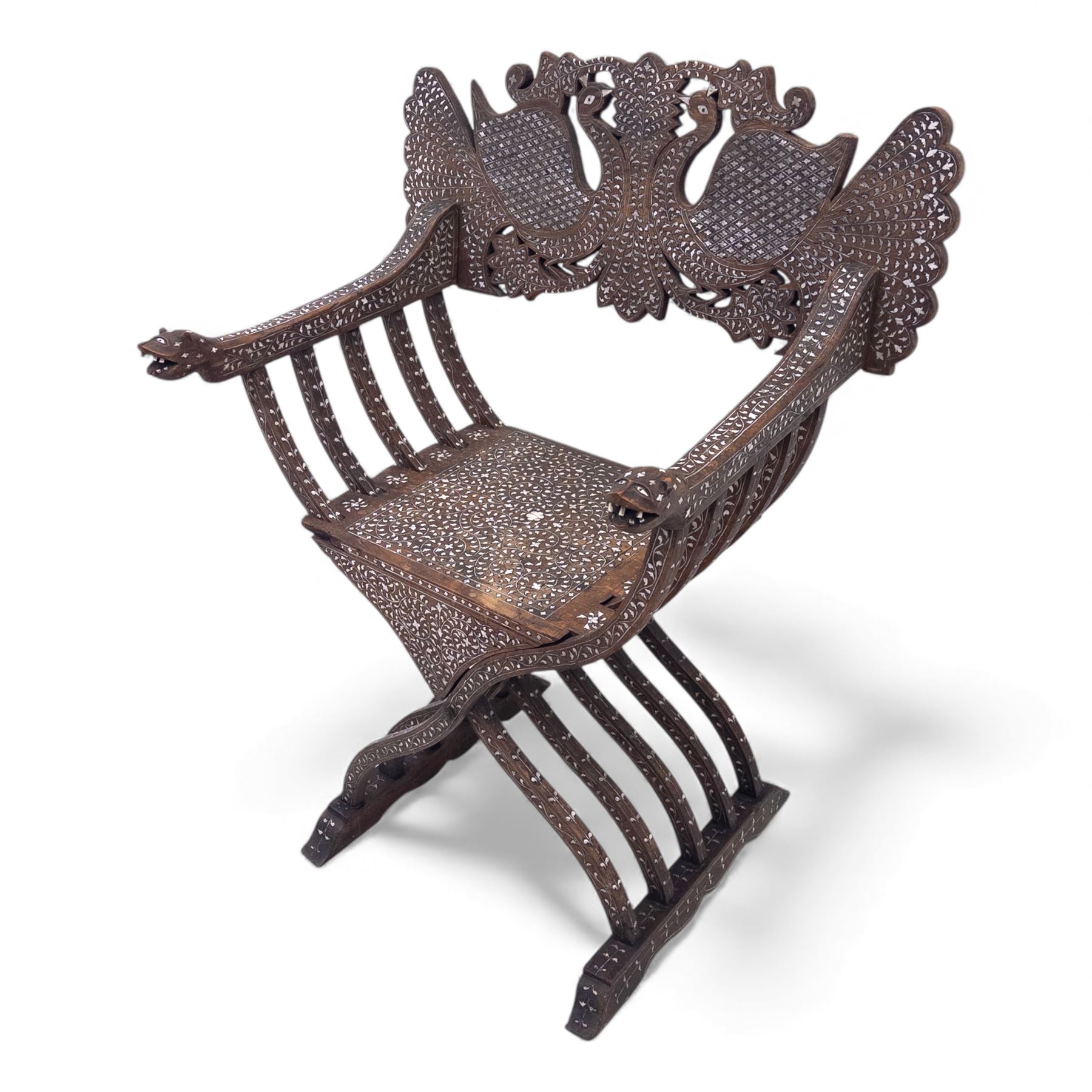 Anglo-Indian bone inlaid hardwood Savonarola chair, the pierced back finely carved with opposing peacocks amongst scrolling foliage, the seat, arms, and X-frame supports. This item has been registered for sale under section 10 of the APHA Ivory Act Reference QWLLGKZM