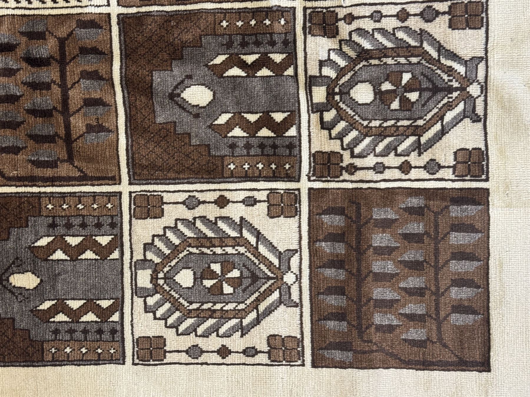 Mid-20th century Persian Bakhtiari rug, ivory ground with alternating dark brown and ivory panels featuring geometric and floral designs, bordered by a plain ivory band