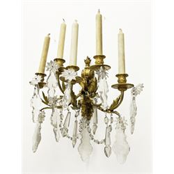 19th century ormolu wall sconce, the shaped and scroll back with flambeau finial supporting five curved branches with acanthus detail and cut glass drops, leading to part fluted sockets and beaded dip pans, H32cm