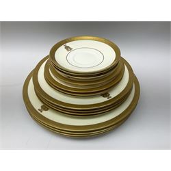 Minton part dinner service, decorated with gold rim and crest, pattern number K154, comprising four dinner plates, five dessert plates, four side plates, two smaller side plates, three saucers, and two teacups, in one box 