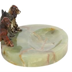 Art Deco ashtray, the oval green onyx tray with oval dished recess, the edge surmounted with three cold painted bronze dogs, comprising Irish Setter, Scottish Terrier and Springer Spaniel, each marked with incised H to base of foot, tray L17cm