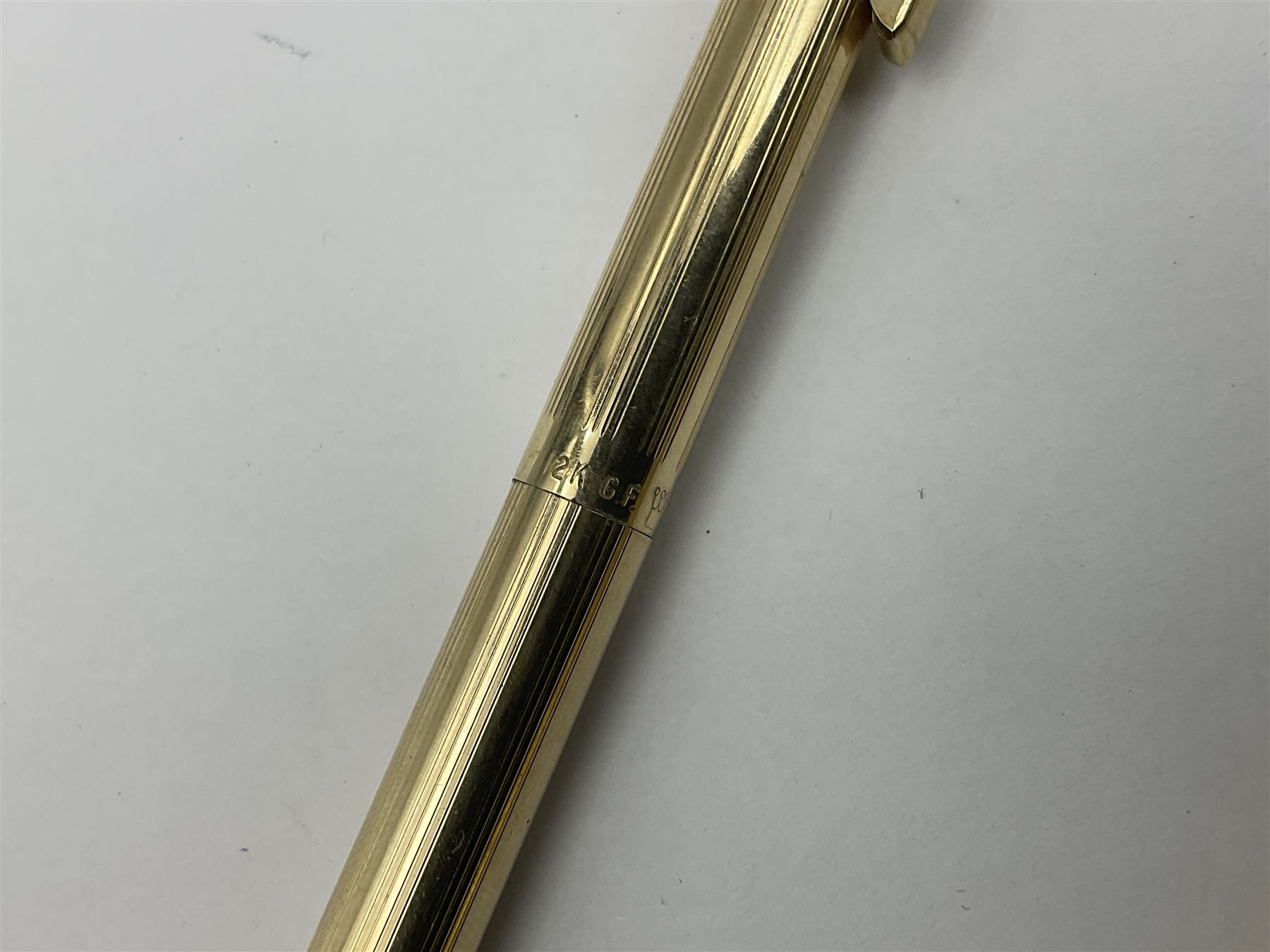 Sheaffer Triumph Imperial fountain pen, the gold plated barrel with fluted stripe design and gold nib stamped 14K 585, together with a Sheaffer Targa slimline fountain pen with gold plated barrel similarly decorated with gold nib stamped 14K 585, ballpoint pen and propelling pencil, each with a fluted gold plated barrel, largest L13.5cm (4)