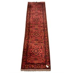 Persian red ground runner, decorated with four Herati motif medallions, the border decorated with repeating plant motif design
